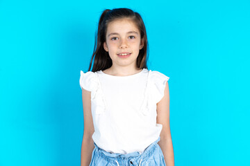 Caucasian kid girl wearing  white t-shirt over blue background with nice beaming smile pleased expression. Positive emotions concept - Powered by Adobe