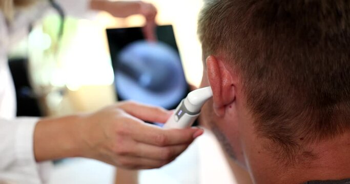 Otorhinolaryngologist examines patient ear with digital otoscope. Hearing test for adults