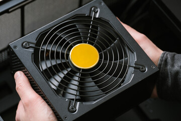 A computer technician installs a computer power supply. Assembling PC