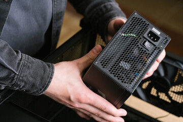 A computer technician installs a computer power supply. Assembling PC