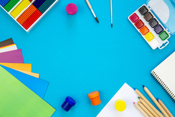 Various school education and office supplies, accessories on a blue background.