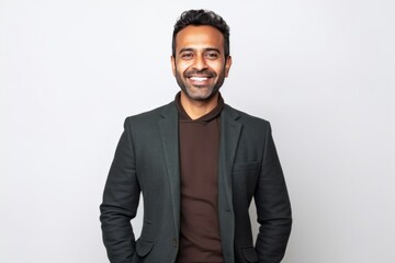 Medium shot portrait of an Indian man in his 30s against a white background