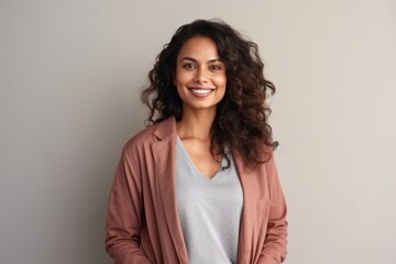 Fototapeta premium Medium shot portrait of an Indian woman in her 30s in a minimalist background