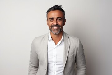 Medium shot portrait of an Indian man in his 40s in a minimalist background