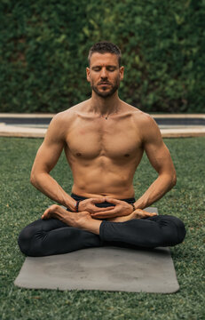 man doing yoga meditation in a park