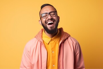 Fototapeta premium Medium shot portrait of an Indian man in his 30s wearing hijab in a colorful background