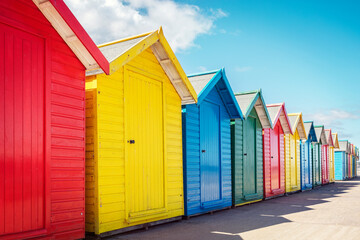 Beach huts or bathing houses on the beach with blue sky background - obrazy, fototapety, plakaty