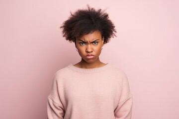 Fototapeta na wymiar Anger African Girl In A Black Cardigan On Pastel Background . Сoncept Mental Health In African Girls, Expressing Anger Nonverbally, Afrocentric Fashion, Pastel Backgrounds In Photography