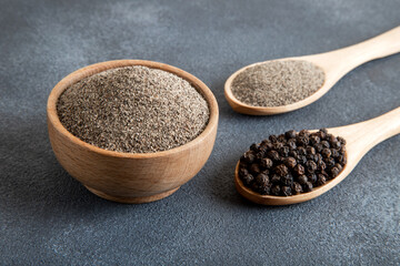 Ground black pepper with grains of black pepper on dark background