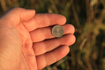 Small foreign coin in hand