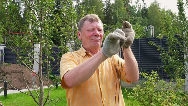 Senior male bend metal wire for formwork with cement to strengthen base for fencing the future garden in the backyard