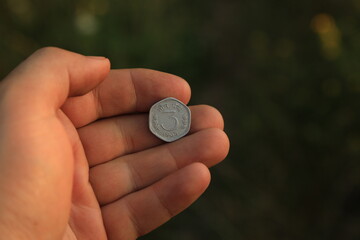 Coin three rupees in hand