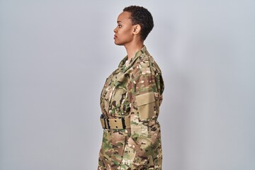 Beautiful african american woman wearing camouflage army uniform looking to side, relax profile...
