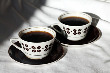 The Two Cups of Coffee on a White Fabric Background