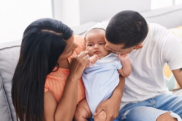 Hispanic family smiling confident sitting on sofa at home