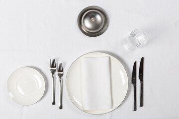 Various setup servings with plate, fork, knife on white table