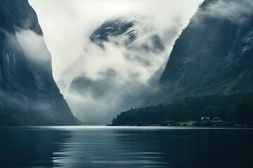 Houses on the coast of the sea bay and foggy fjords in the background. - obrazy, fototapety, plakaty