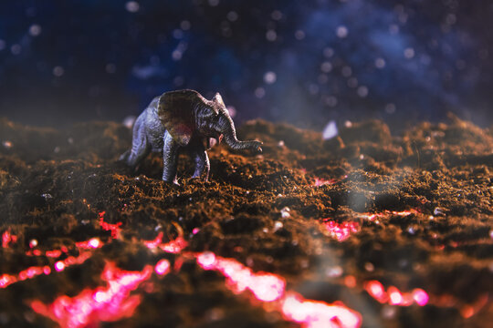Elephant walks on burning lava. Creative scenery with a small miniature.