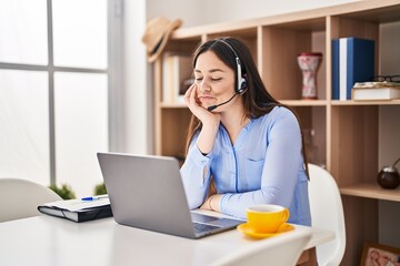 Young brunette woman wearing call center agent headset thinking looking tired and bored with depression problems with crossed arms.