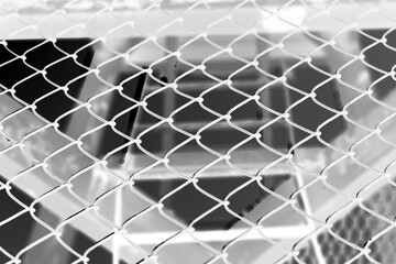 A steel security fence in a black and white film negative.