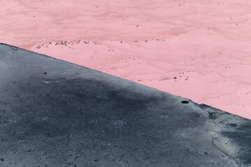 A minimalist view of a concrete pier along the seashore in a bright pink red film negative.