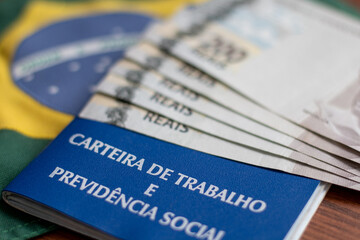 Brazilian document work and social security ( Carteira de Trabalho e Previdencia Social) with brazilian money and flag