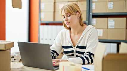 Fototapeta na wymiar Young blonde woman ecommerce business worker using laptop working at office