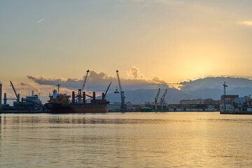Sunset behind cranes in port in Malaga Spain