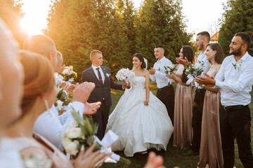 Wide angle shot of bride and groom walking down the aisle after their wedding ceremony at sunset as...