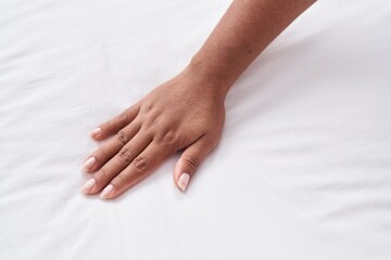 Fototapeta na wymiar African american woman touching bedsheet at bedroom