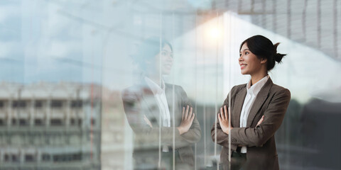Young asian businesswoman looking out window in meeting room with confidence