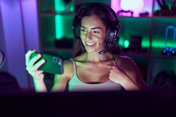 Young brunette woman playing video games with smartphone pointing finger to one self smiling happy and proud © Krakenimages.com