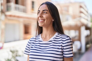 Young hispanic woman smiling confident standing at street