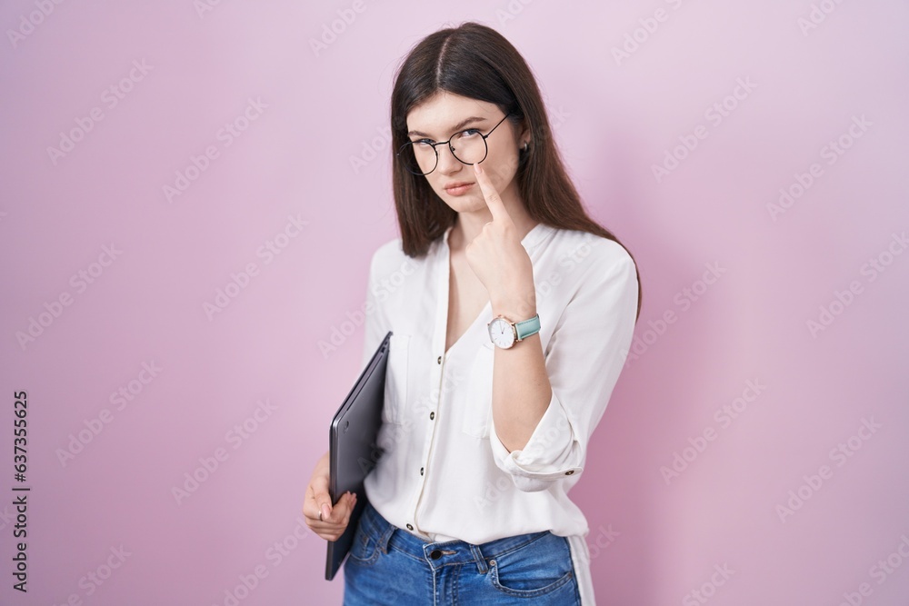 Canvas Prints Young caucasian woman holding laptop pointing to the eye watching you gesture, suspicious expression