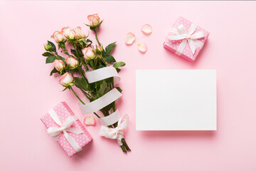 Greeting holiday card mockup with fresh roses on colored table background, mock up with copy space for design