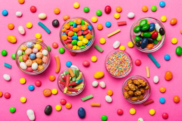 different colored round candy in bowl and jars. Top view of large variety sweets and candies with copy space