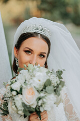 Portrait of the bride with a bouquet. A beautiful young bride holds a wedding bouquet in her hands....