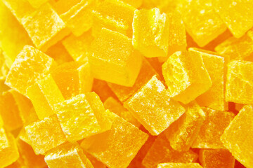 Diced mango dried fruits texture background, top view. Dehydrated mango chips dices, sweet food closeup