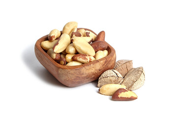 Brazil nuts in wooden bowl isolated on white. Peeled brazil nuts.