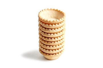 Unfilled tartlet shells isolated on white background. Stacked empty crispy mini tart cups for portable desserts. Tartlet shells awaiting sweet or savory fillings