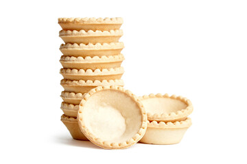 Unfilled tartlet shells isolated on white background. Stacked group of empty mini tart cups for portable desserts. Empty tartlet crusts, a delightful beginning