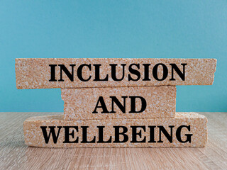 Inclusion and wellbeing symbol. Concept words Inclusion and wellbeing on brick blocks. Beautiful...