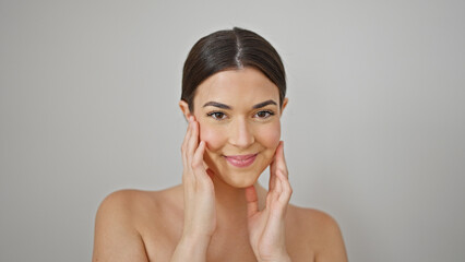 Young beautiful hispanic woman smiling confident massaging face over isolated white background