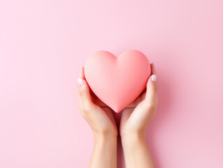 Valentine's Day, pink heart made of paper are held in the hand in love. Top view. Copy space.