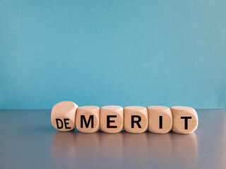 Demerit or merit symbol. Male hand flips the wooden cube and changes words demerit to merit....