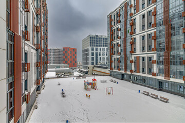 A new residential neighborhood in the capital Moscow with high-rise apartment buildings and an inner courtyard on a winter day with snow in the top view.