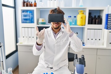 Young arab man scientist using virtual reality glasses working at laboratory