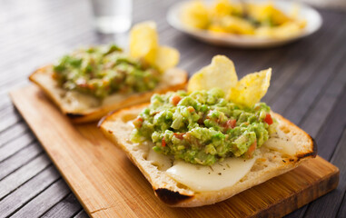 healthy breakfast. toasted italian ciabatta bread with melted cheese and avocado puree