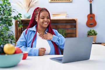 African american woman using laptop communicate with deaf language at home