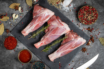 Lamb shank. Raw lamb shank meat on dark background. Butcher products. Top view